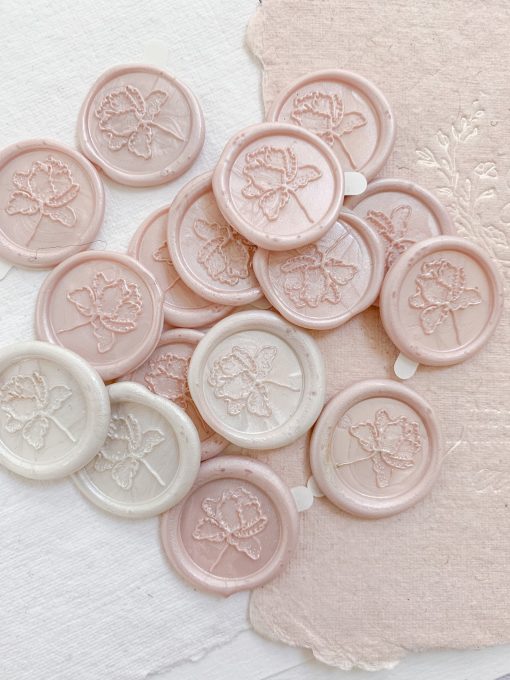 A collection of different coloured branded wax seals with stickers