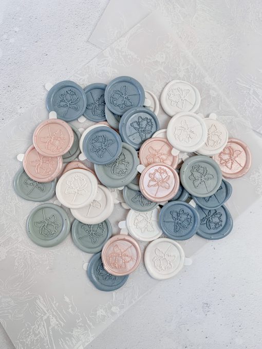 A collection of different coloured branded wax seals with stickers