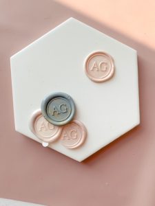 Branded wax seal stamp in different shades of grey and pink wax.