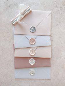 5 wax seals on different coloured envelopes