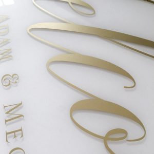 Welcome sign with gold foil on clear acrylic and white paint